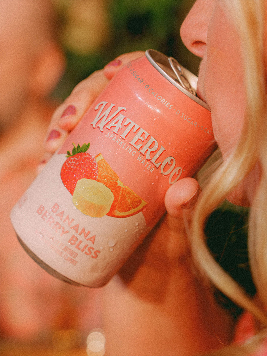 Close-up of a person enjoying a can of Waterloo Sparkling Water, Banana Berry Bliss flavor.