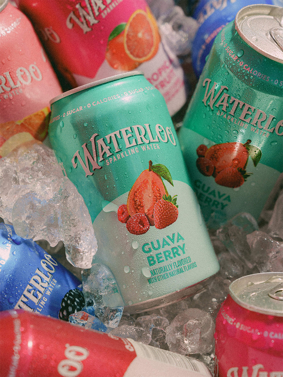 Waterloo sparkling water cans in a mix of flavors including Guava Berry, surrounded by ice.