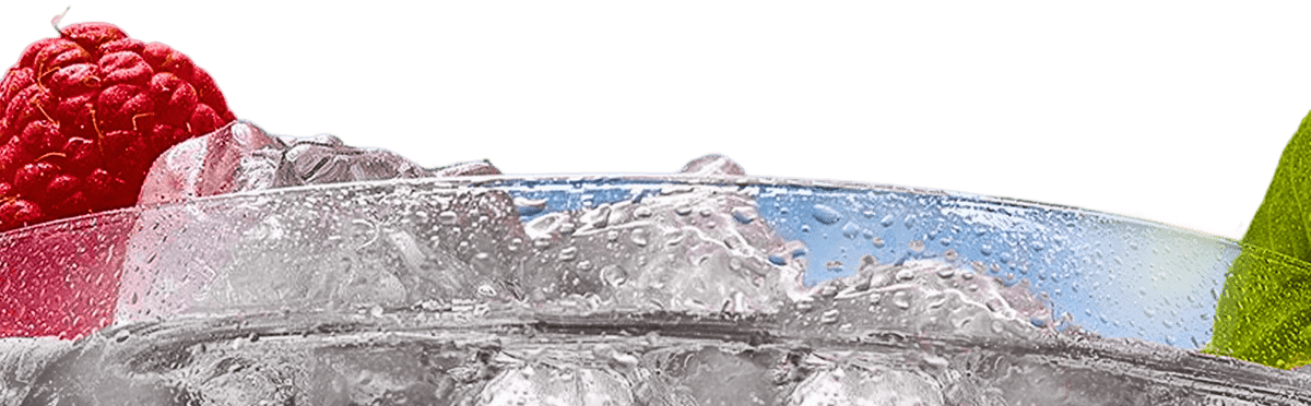 Close-up of a refreshing drink with raspberries and a lime slice, surrounded by ice and condensation.