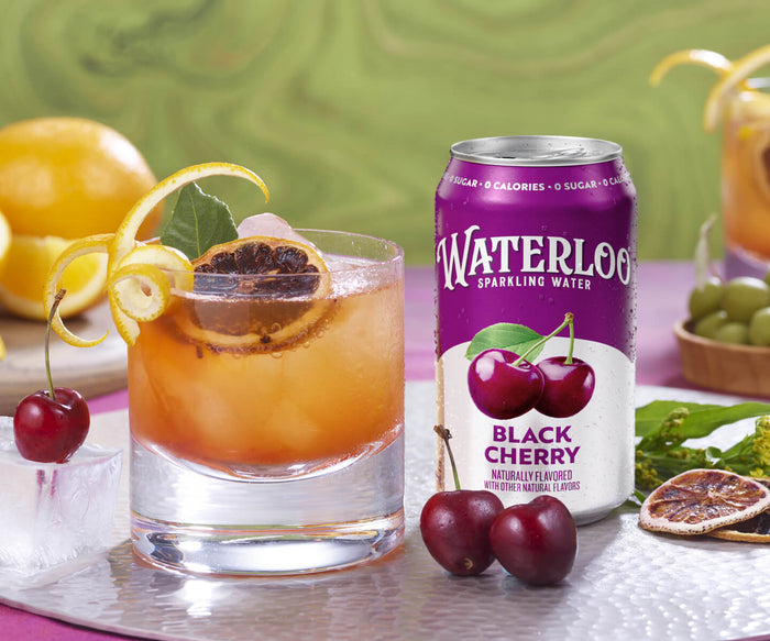 A refreshing glass of cocktail with black cherry Waterloo sparkling water and garnished with lemon and cherries.