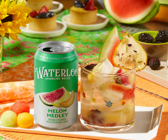 Waterloo Melon Medley sparkling water can beside a refreshing drink with fruit on a vibrant table setting.