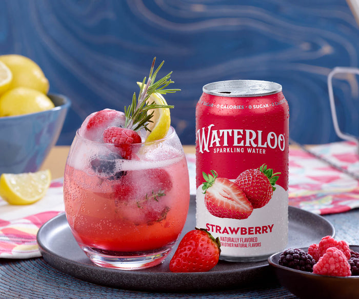 A refreshing glass of Waterloo strawberry sparkling water with raspberries and lemon, set on a stylish table.