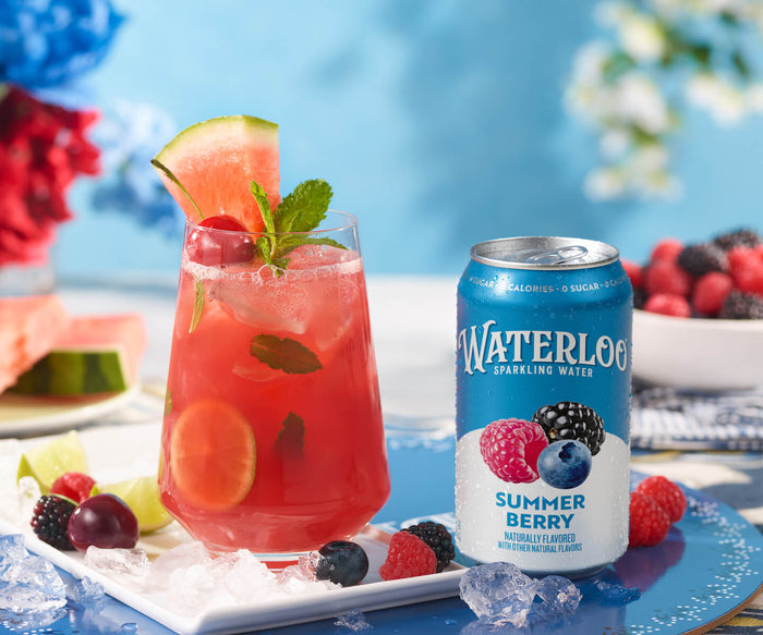 Refreshing Waterloo Summer Berry sparkling water next to a vibrant cocktail garnished with fruit and mint.