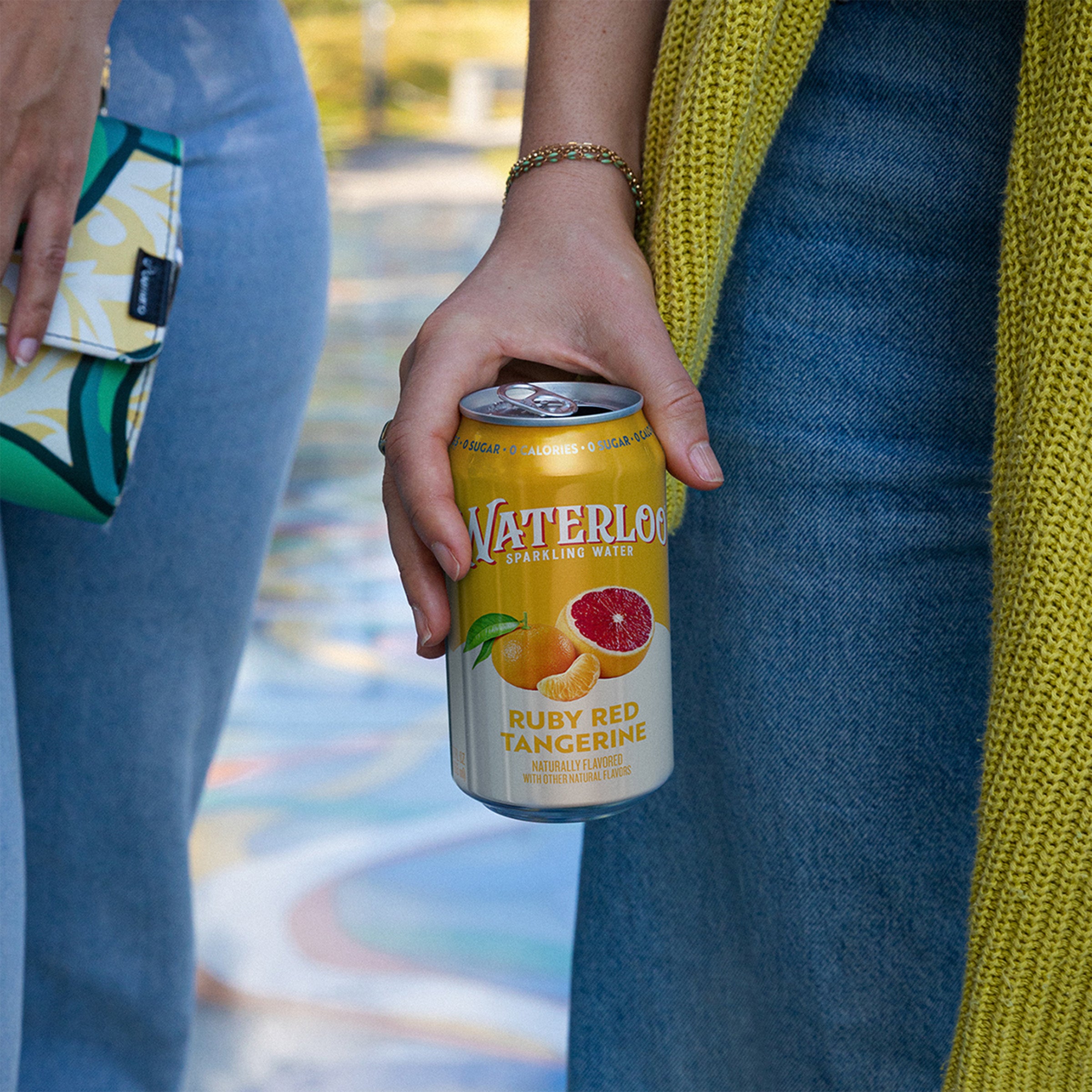 Person holding a can of Waterloo Sparkling Water featuring Ruby Red Tangerine flavor.