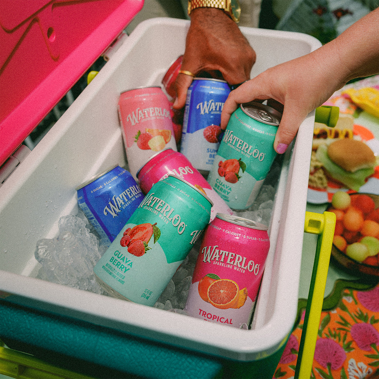 Colorful cans of Waterloo sparkling water in a cooler with ice, showcasing flavors like Tropical and Guava Berry.
