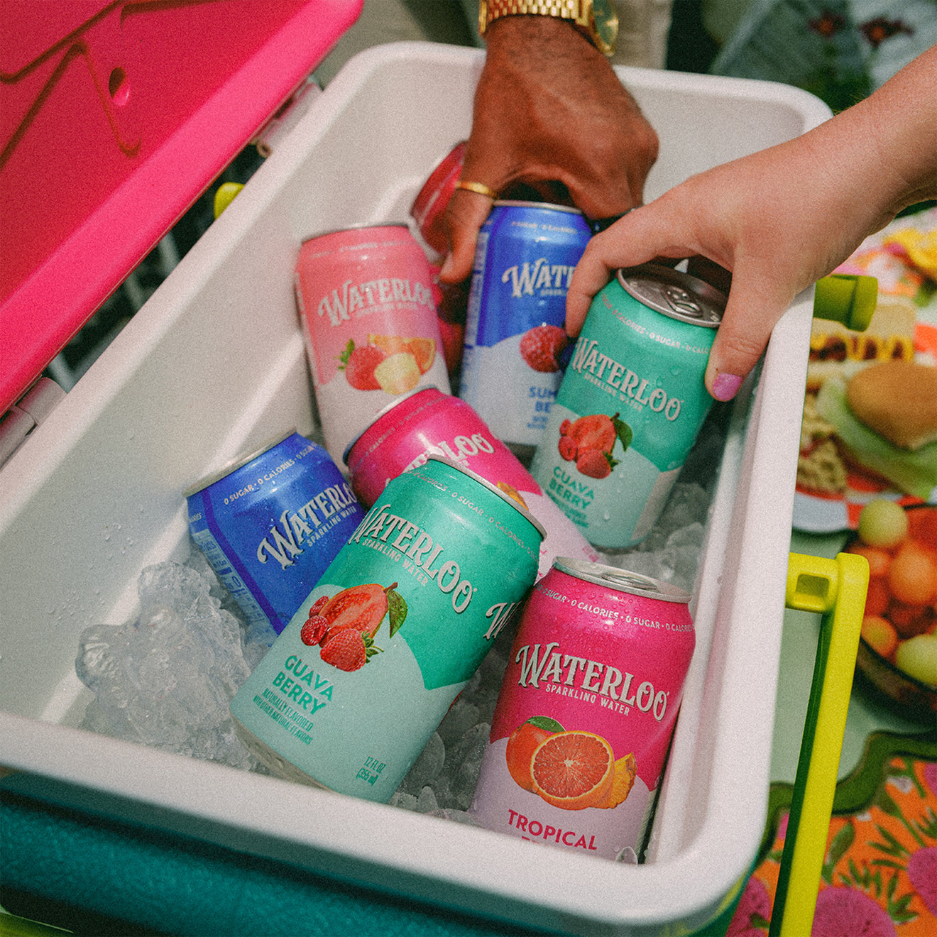 Assorted Waterloo sparkling water cans in a cooler filled with ice, showcasing tropical flavors for summer refreshment.