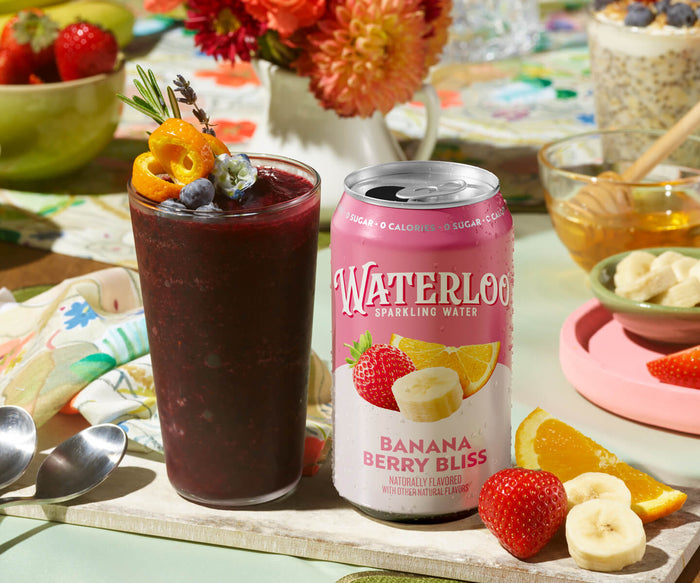 A refreshing glass of banana berry smoothie with a can of Waterloo sparkling water, garnished with fruits.