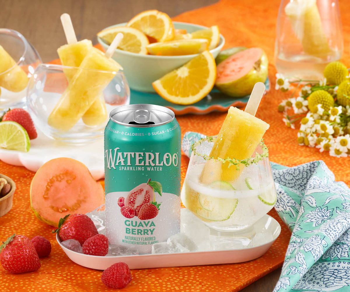 Waterloo Guava Berry sparkling water with popsicles, fresh fruits, and vibrant table setting for a refreshing summer drink.