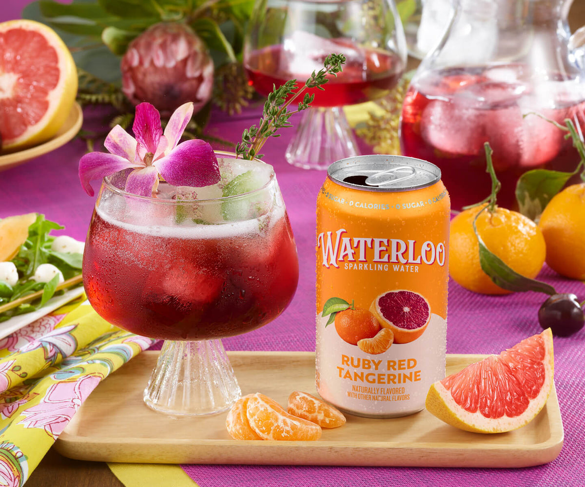 Refreshing Waterloo Ruby Red Tangerine sparkling water with ice, garnished with a flower, on a vibrant table setting.