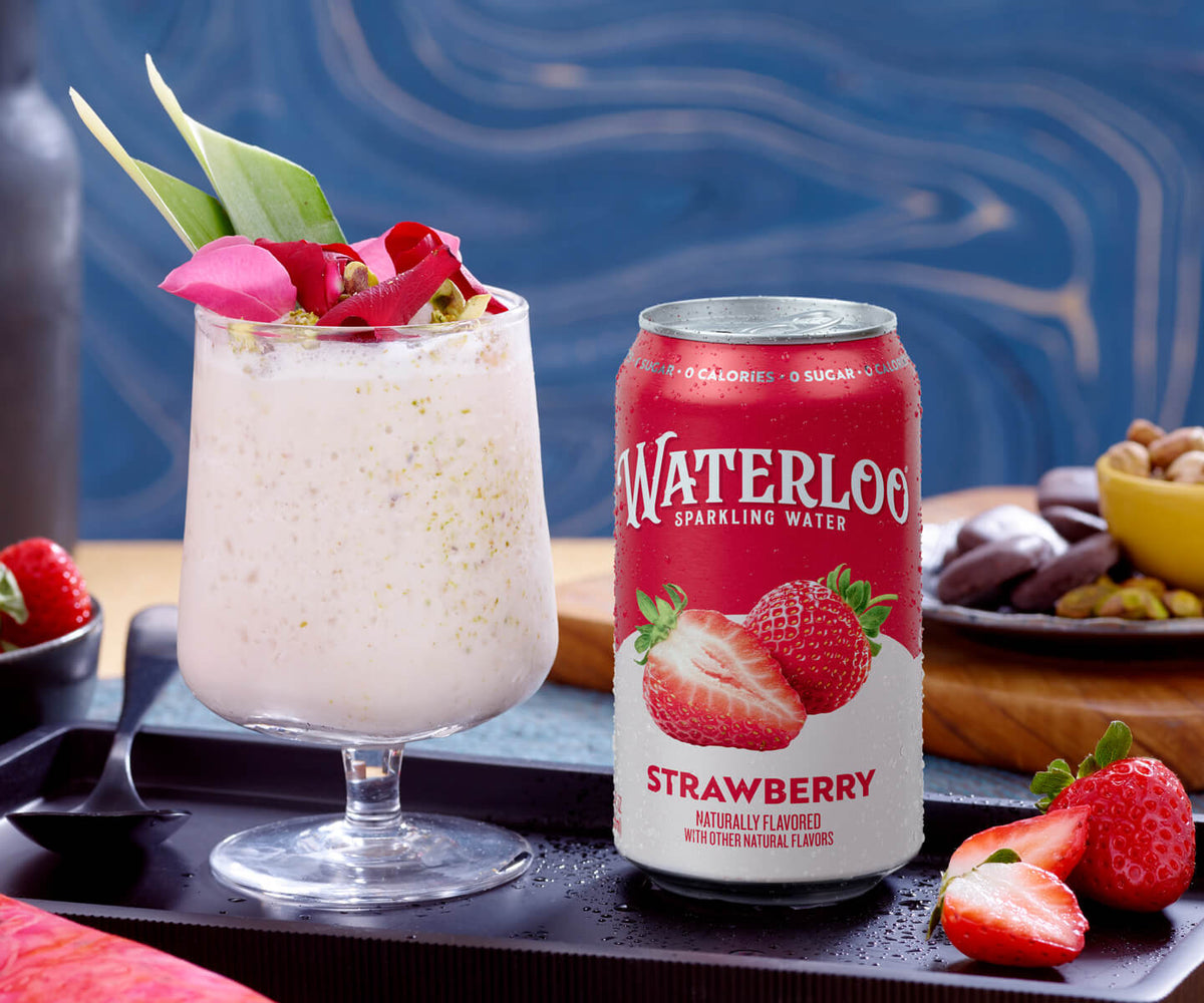Refreshing Waterloo Strawberry sparkling water can beside a creamy drink garnished with flowers and fresh strawberries.