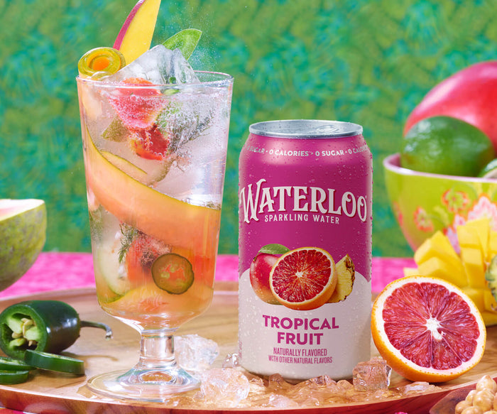 A refreshing glass of Waterloo Tropical Fruit sparkling water, garnished with fresh fruit and accompanied by a vibrant background.