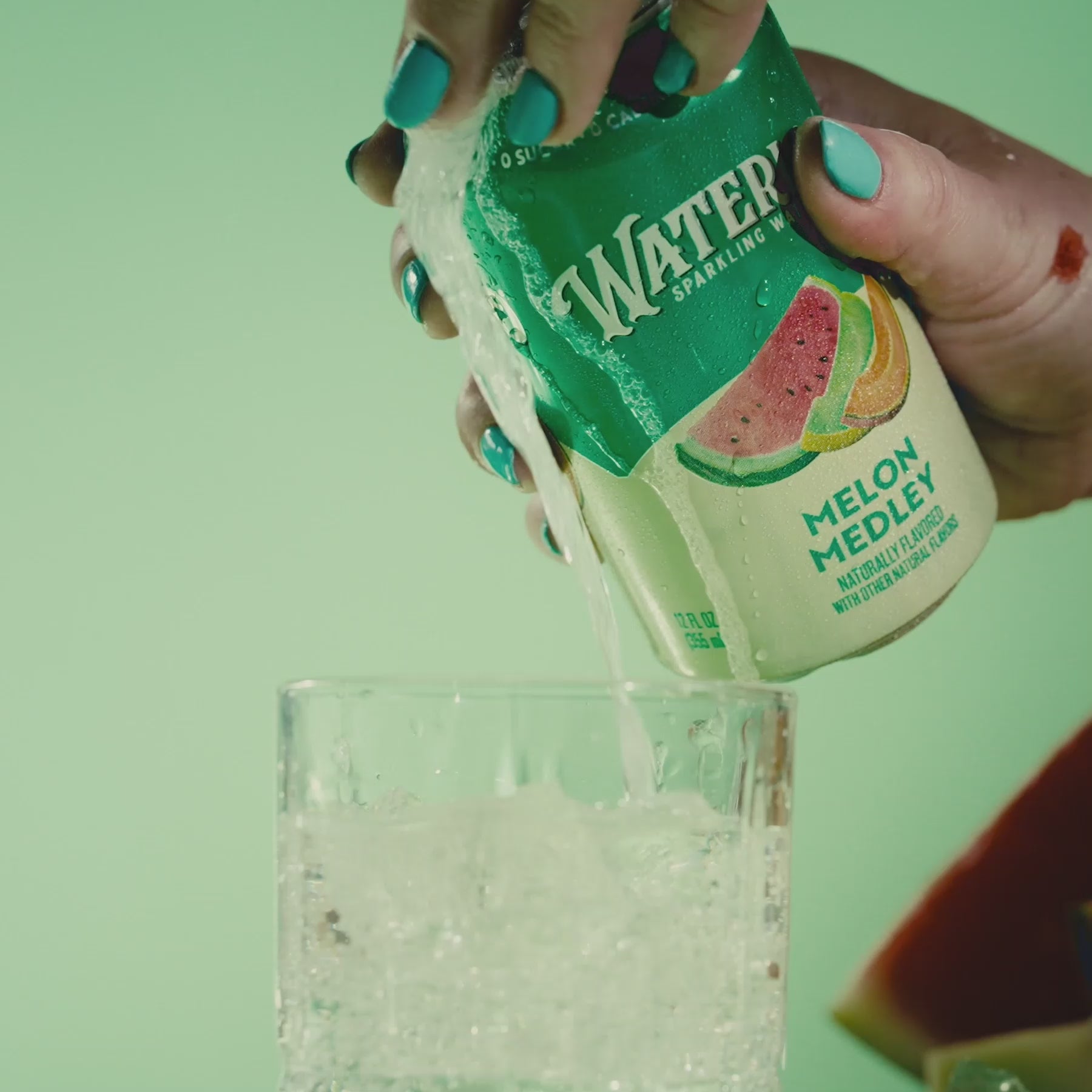 Person pouring a can of Watery Sparkling Water, flavor Melon Medley, into a glass filled with ice.