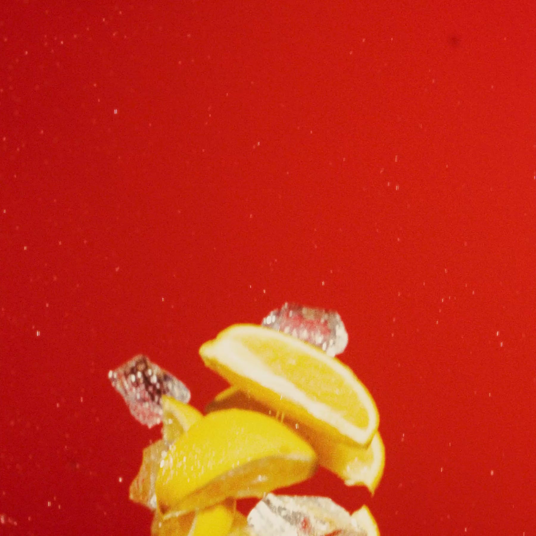 Lemon Italian Ice with fresh lemon slices and ice on a vibrant red background.