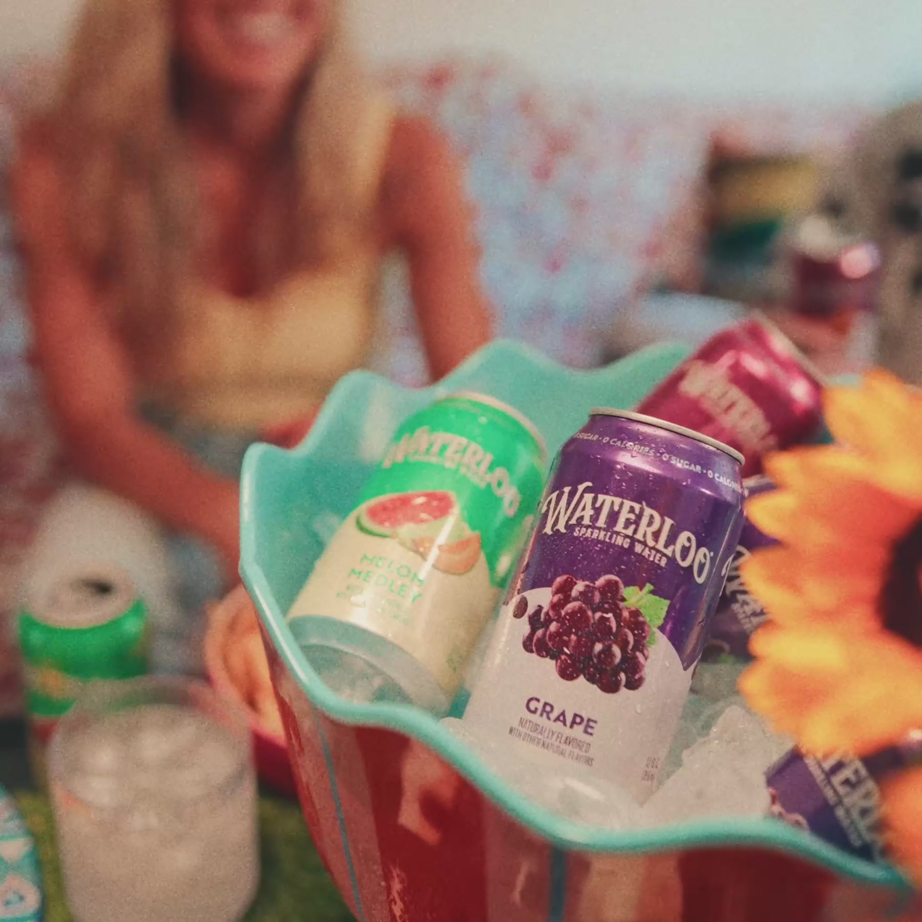 A colorful display of Waterloo sparkling water cans, featuring Grape flavor, sitting in a chilled bowl with ice.
